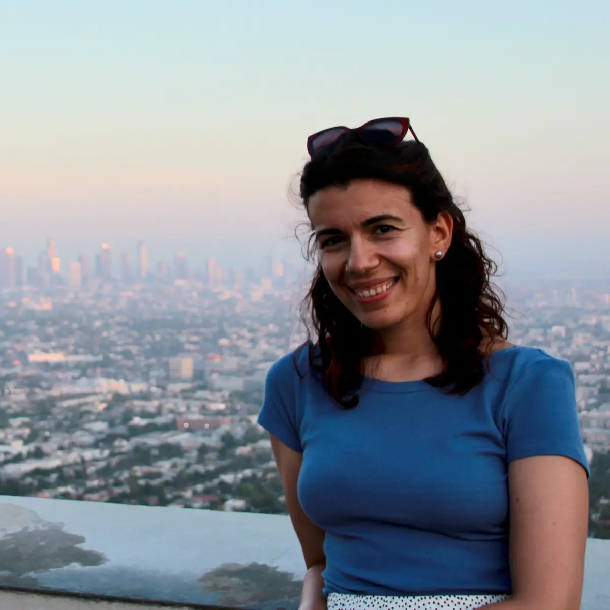 Chiara, ELA and literature teacher and blogger, smiling with a city skyline behind her.